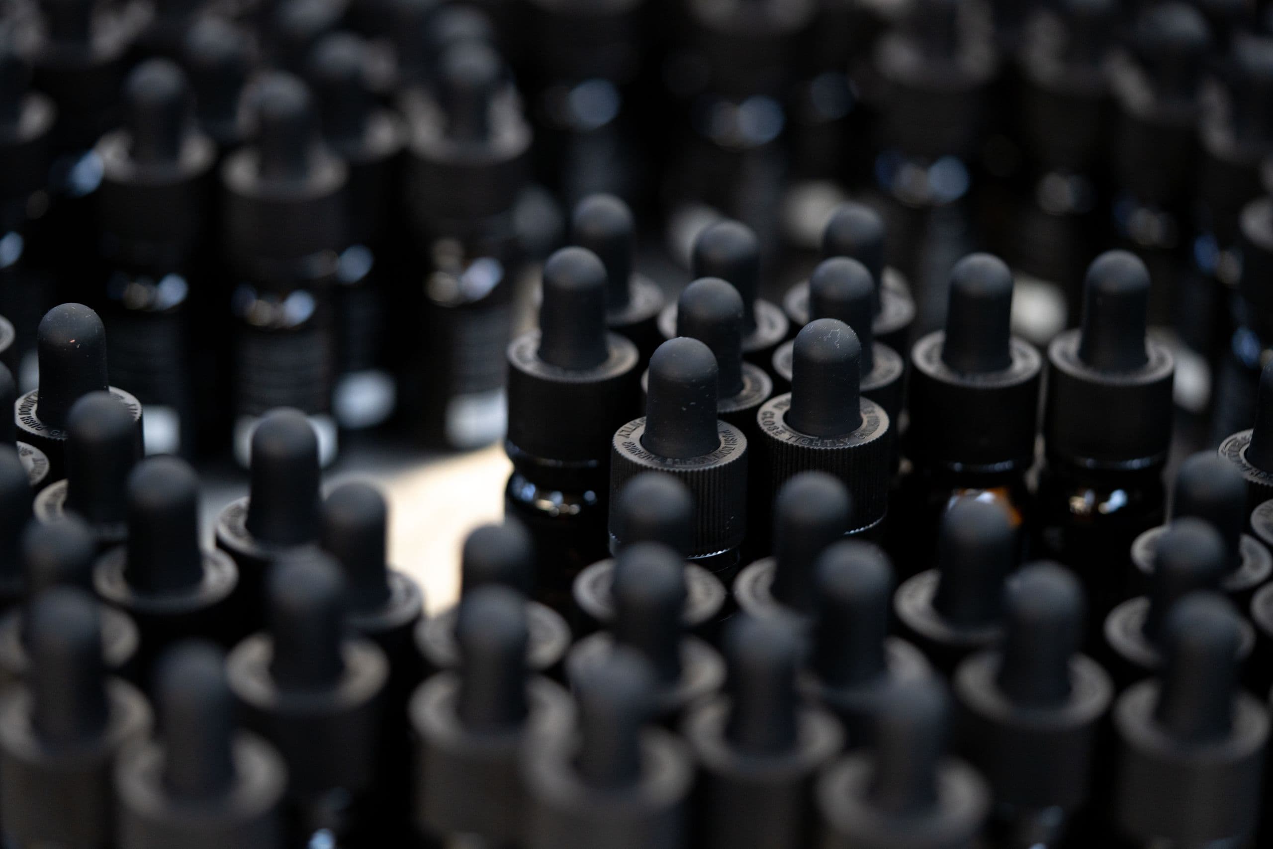 Schwarze CBD-Tropfflaschen in großer Menge, geeignet für Online-Shop, spezialisierte Aufbewahrung von CBD-Ölen und Tinkturen.