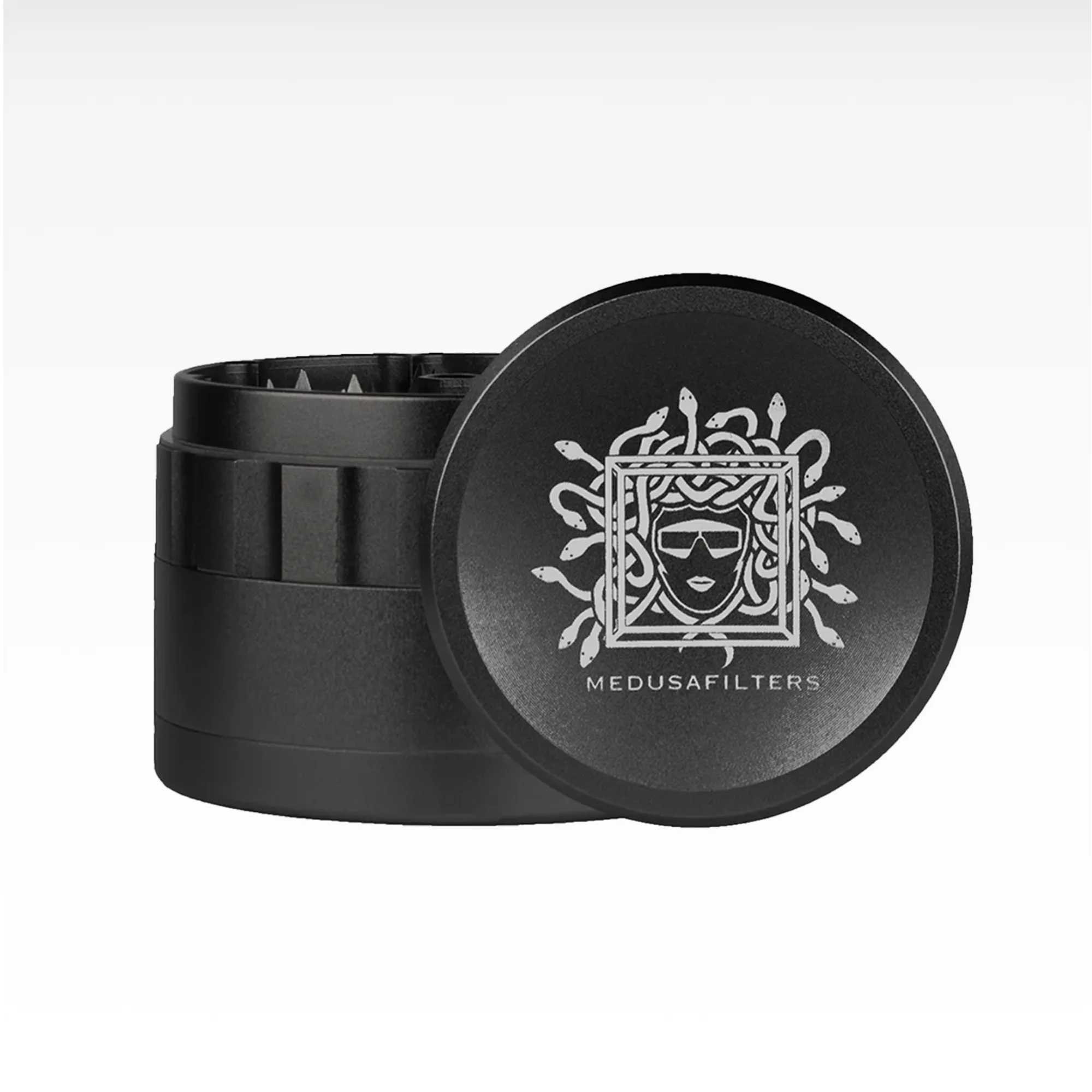 Schwarzer Metall-Grinder mit Medusafilters-Logo und sichtbaren Mahlzähnen